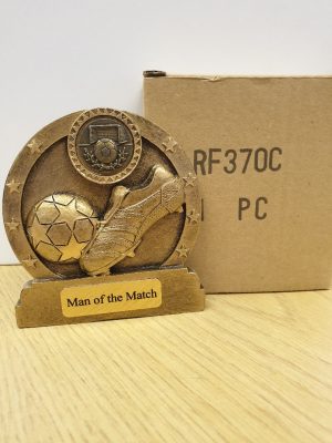 Image showing small round football trophy with boot kicking ball with box against white background
