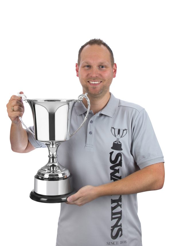 Image showing man holding studio silver plated large trophy cup against white background